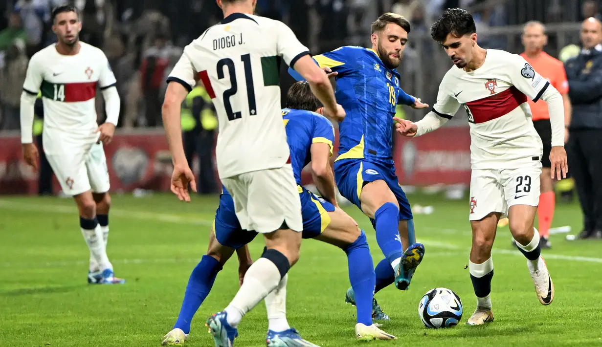 Gelandang Portugal #23 Vitinha (kanan) berebut bola dengan penyerang Bosnia-Herzegovina #19 Said Hamulic pada lanjutan Grup J Kualifikasi Euro 2024 di Stadion Bilino Polje, Selasa (17/10/2023) WIB. (Elvis BARUKCIC / AFP)