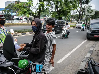 Polisi Lalu lintas menilang pengendara sepeda motor saat Operasi Patuh Jaya 2020 di Jalan Letjen Suprapto, Jakarta Pusat, Kamis (23/7/2020). Ditlantas Polda Metro Jaya menggelar Operasi Patuh Jaya 2020 hingga 5 Agustus untuk menertibkan masyarakat dalam berlalu lintas. (Liputan6.com/Faizal Fanani)