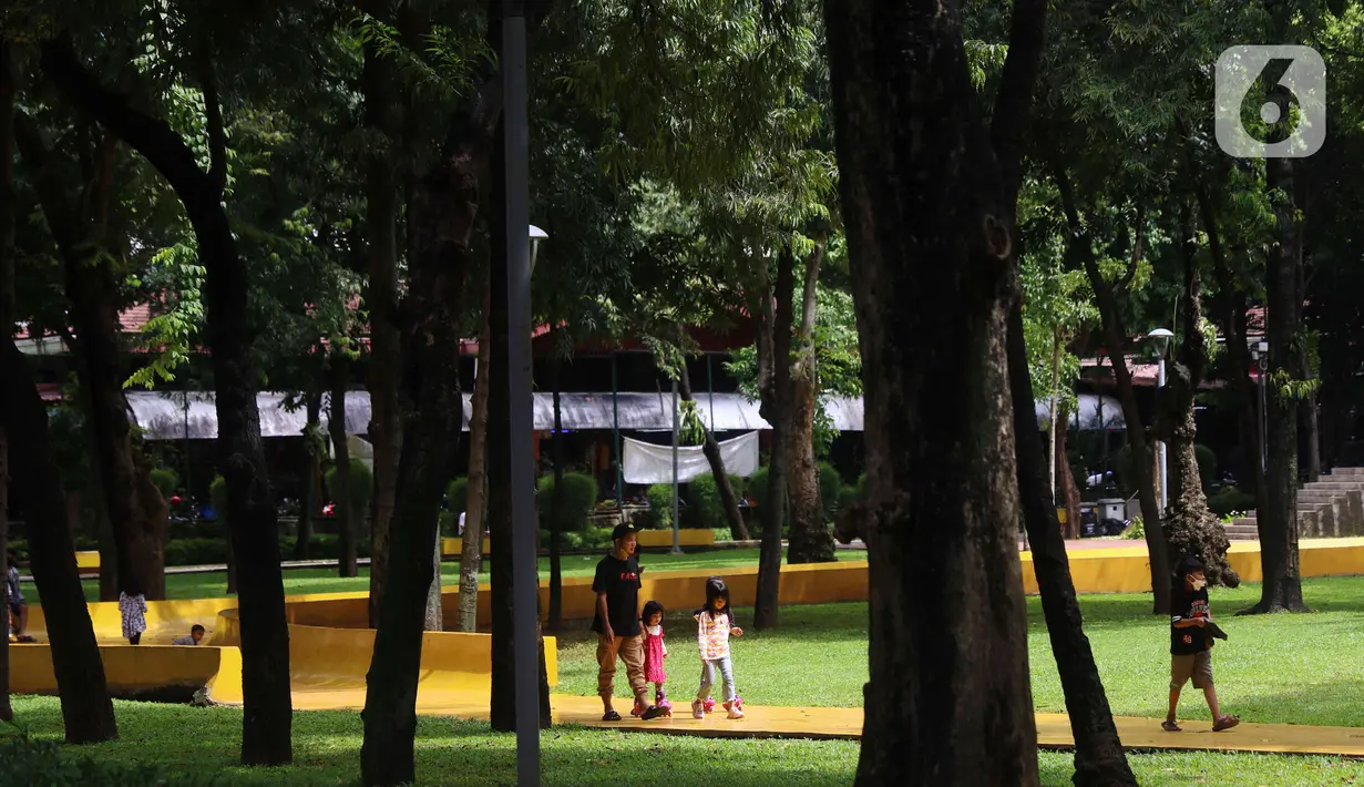 Anak-anak berjalan di area Taman Puring, Jakarta Selatan, Minggu (26/12/2021). Memanfaatkan libur Natal dan Tahun Baru banyak warga memanfaatkan bersama keluarga berwisata ke taman karena hemat biaya. (Liputan6.com/Angga Yuniar)