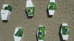 Bendera nasional Brasil yang dilubangi untuk mewakili anak-anak yang terbunuh oleh peluru nyasar dibentangkan di atas peti mati sebagai bagian dari protes di pantai Copacabana, Rio de Janeiro, Brasil, Sabtu, 19 Agustus 2023. (AP Photo/Bruna Prado)