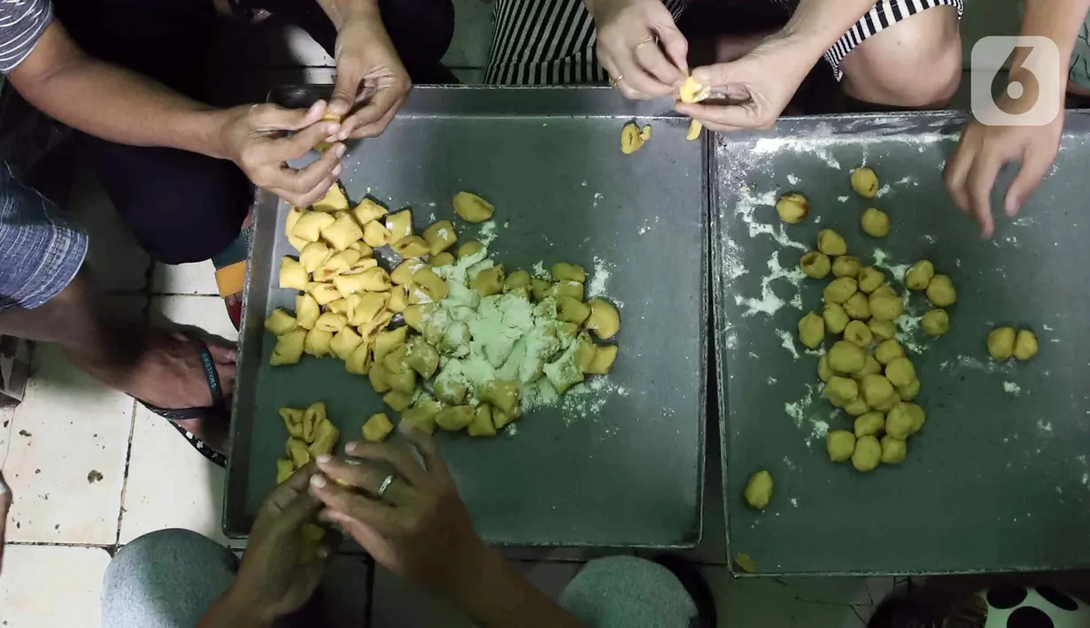 Para pekerja menyelesaikan pembuatan kue kering skala rumah tangga Pusaka Kwitang di kawasan Senen, Jakarta, Rabu (13/4/2022). Harga jual kue kering Ramadhan naik dari Rp 70.000 per kilogram pada tahun lalu menjadi Rp 80.000 - Rp 85.000 per kilogram. (Liputan6.com/Herman Zakharia)