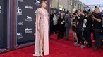 Penyanyi Taylor Swift berpose di karpet merah saat tiba menghadiri Billboard Music Awards di MGM Grand Garden Arena di Las Vegas (20/5).Taylor Swift tampil cantik dengan gaun Versace warna merah muda dengan belahan paha tinggi. (AP Photo/Jordan Strauss)