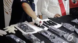 Petugas memperlihatkan narkoba yang dikemas dalam bentuk spare part motor, Jakarta, Senin (22/12/2014). (Liputan6.com/Faizal Fanani)