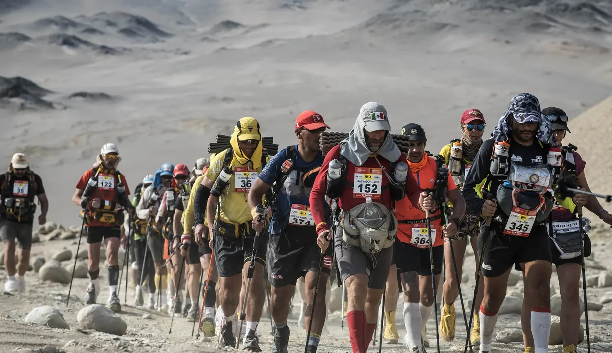 Para peserta berjalan saat mengikuti lomba marathon sejauh 250 kilometer di Gurun Ica, Kamis (30/11/2017). Marathon yang terbagi dalam enam tahapan ini diprediksi akan berakhir pada 4 Desember. (AFP/Jean-Philippe Ksiazek)