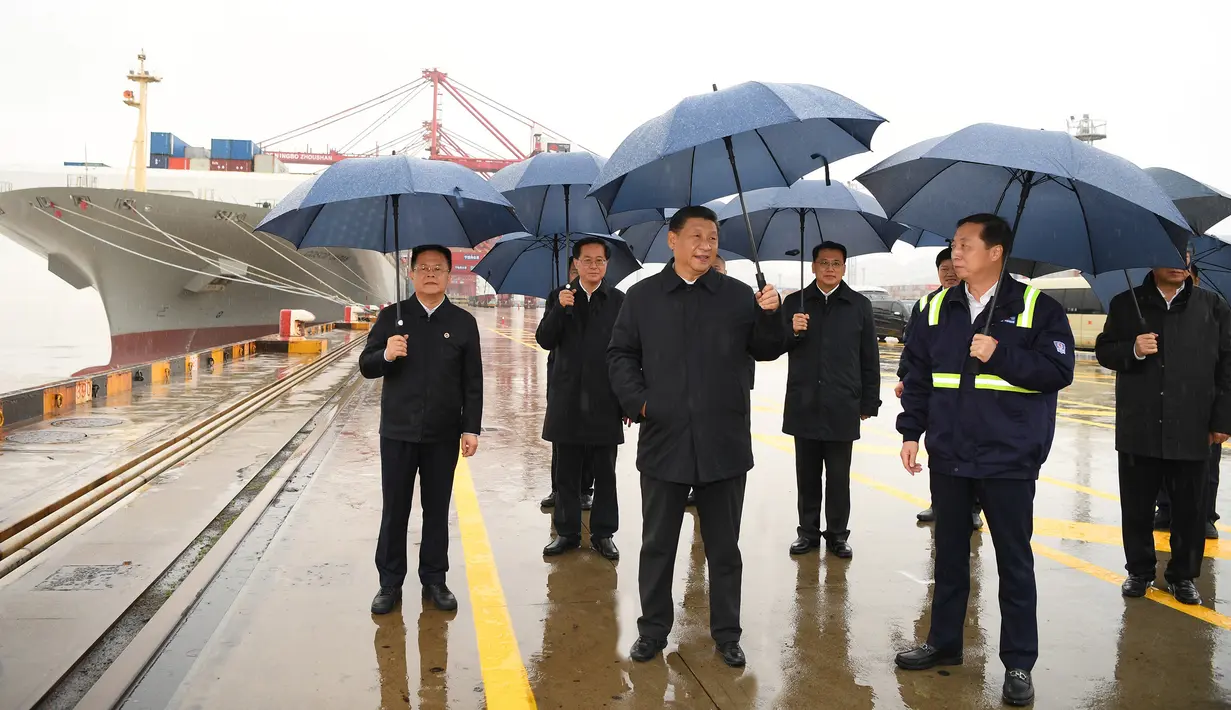 Presiden China Xi Jinping (tengah) saat mengunjungi kawasan pelabuhan Chuanshan di Pelabuhan Ningbo-Zhoushan, Provinsi Zhejiang, China, Minggu (29/3/2020). Xi Jinping melakukan inspeksi terhadap proses dimulainya kembali kegiatan kerja dan produksi di Zhejiang. (Xinhua/Shen Hong)