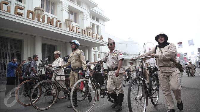 Aksi peserta parade menggunakan sepeda kuno lengkap dengan atribut untuk menuju Gedung Merdeka, Bandung, Jawa Barat, Rabu (1/6/2016). Kegiatan ini untuk memperingati momen bersejarah yang dialami oleh bangsa Indonesia. (Liputan6.com/Faizal Fanani)