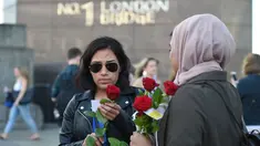 Mawar yang disertai sebuah pesan dibagikan kepada para pejalan kaki di London Bridge, Minggu (11/6). Muslim Inggris membagikan ratusan mawar sebagai bentuk solidaritas menyusul serangan teror London yang terjadi pekan lalu. (David Mirzoeff/PA via AP)