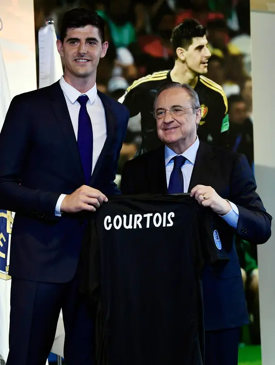 Kiper asal Belgia Thibaut Courtois menunjukkan jersey klub barunya Real Madrid saat berpose dengan presiden Real Madrid, Florentino Perez  di stadion Santiago Bernabeu (9/8). Courtois dikontrak Madrid selama 6 tahun. (AFP Photo/Javier Soriano)