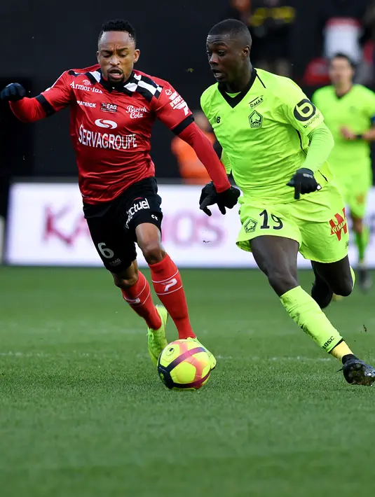 Penyerang Lille, Nicolas Pepe berusaha melewati gelandang Guingamp, Lebogang Phiri  selama pertandingan Liga Prancis  di stadion Roudourou, Perancis pada 10 Februari 2019. Arsenal harus memecahkan rekor transfer klub untuk merekrut Pepe. (AFP Photo/Fred Tanneau)