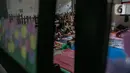 Aktivitas korban banjir di salah ruang kelas di gedung SDN 01/02 Kampung Melayu, Jakarta, Selasa (9/2/2021). Gedung sekolah di Kebon Pala tersebut menjadi salah satu posko pengungsian bagi sebagian korban banjir Kampung Melayu. (Liputan6.com/Faizal Fanani)