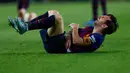 Megabintang Barcelona, Lionel Messi bereaksi setelah mendarat tak sempurna saat terjatuh dalam lanjutan Liga Spanyol di Stadion Camp Nou, Minggu (21/10). Messi mengalami cedera akibat salah jatuh saat berduel dengan pemain Sevilla. (AP/Manu Fernandez)