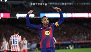 Penyerang Barcelona, Raphinha, memberi isyarat kepada para penggemar selama pertandingan Liga Spanyol antara FC Barcelona dan Club Atletico de Madrid di Stadion Camp Nou, Barcelona, ​​pada 2 Desember 2025. (Josep LAGO / AFP)