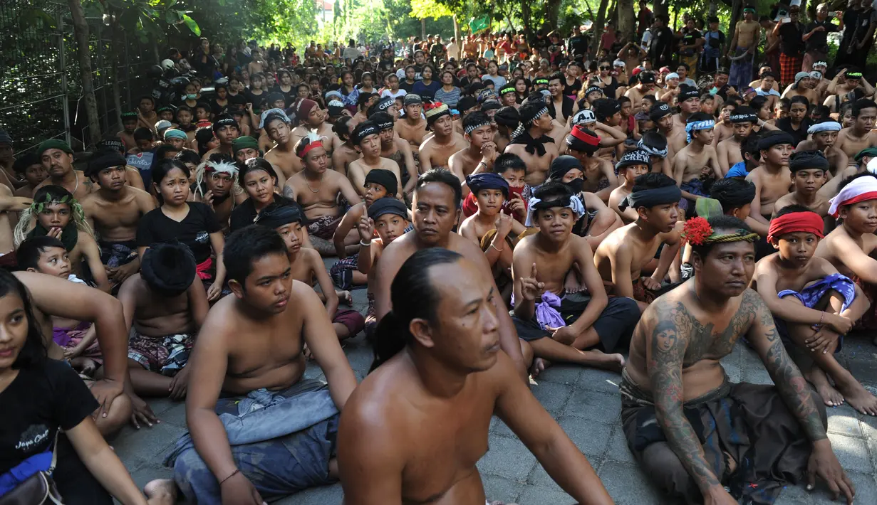 Warga Bali bersiap pergi ke hutan manggrove untuk mandi lumpur tradisional atau yang dikenal sebagai Mebuug-buugan di desa Kedonganan, Bali (18/3). Warga menggelar tradisi unik usai perayaan hari Nyepi lewat mandi lumpur. (AFP/Sony Tumbelaka)