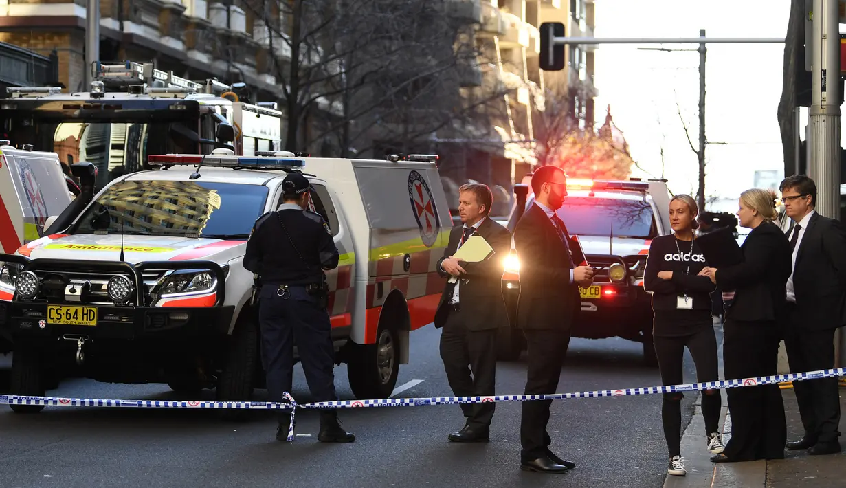 Polisi berjaga di tempat kejadian setelah seorang pria menikam wanita dan berusaha menikam orang lain di pusat kota Sydney (13/8/2019). Polisi NSW mengatakan mereka menerima laporan seorang pria berjalan di sepanjang York Street dengan pisau sekitar pukul 14:00. (AFP Photo/Saeed Khan)