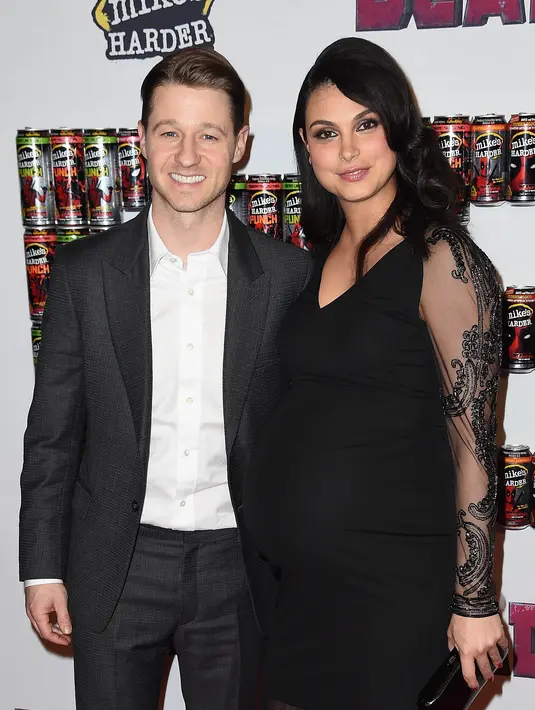 Morena Baccarin mengenakan gaun dengan potongan ‘v-neck’ gelap sepanjang paha, sementara kekasihnya, Benjamin McKenzie tampak necis dalam setelan jas abu-abu dengan kemeja berwarna putih di dalamnya. (AFP/Bintang.com)