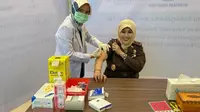 Kepala Kejati Riau Mia Amiati disuntik vaksin influenza sebagai antisipasi dari virus corona. (Liputan6.com/M Syukur)