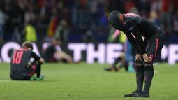 Pemain Arsenal, Alexandre Lacazette (kanan) menutup wajahnya usai kalah dari Atletico pada semifinal Liga Europa di Wanda Metropolitano stadium, Madrid, (3/5/2018). Atletico menang 1-0. (AP/Francisco Seco)