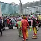 Aksi badut yang tergabung dalam Aku Badut Indonesia menghibur masyarakat saat car free day di Bunderan HI, Jakarta, Minggu (9/12). Aksi tersebut bentuk kampanye positif bertujuan mengajak masyarakat peduli terhadap sesama. (Liputan6.com/Faizal Fanani)