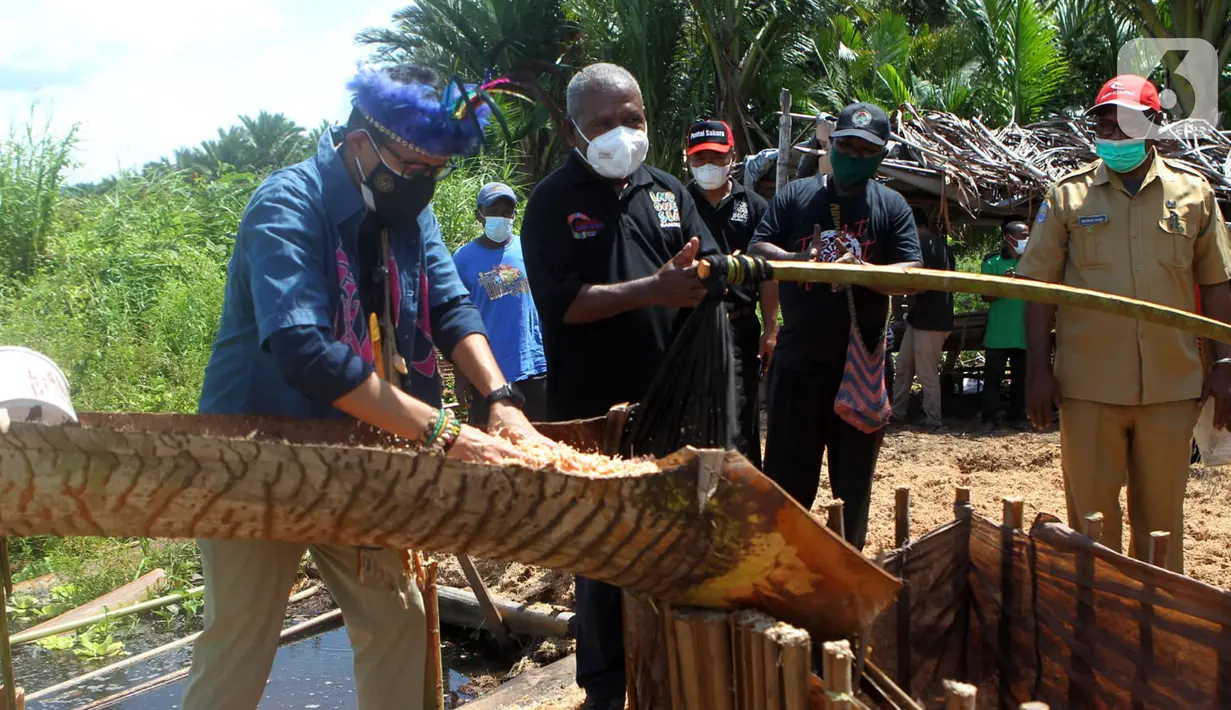 Menteri Parekraf Sandiaga Salahuddin Uno bersama Bupati Jayapura, Mathius Awoitauw mencoba membuat sagu di Kampung Yoboi Danau Sentani, Kabupaten Jayapura, Papua, Selasa (21/9/2021). (Liputan6.com/HO/Parekraf)
