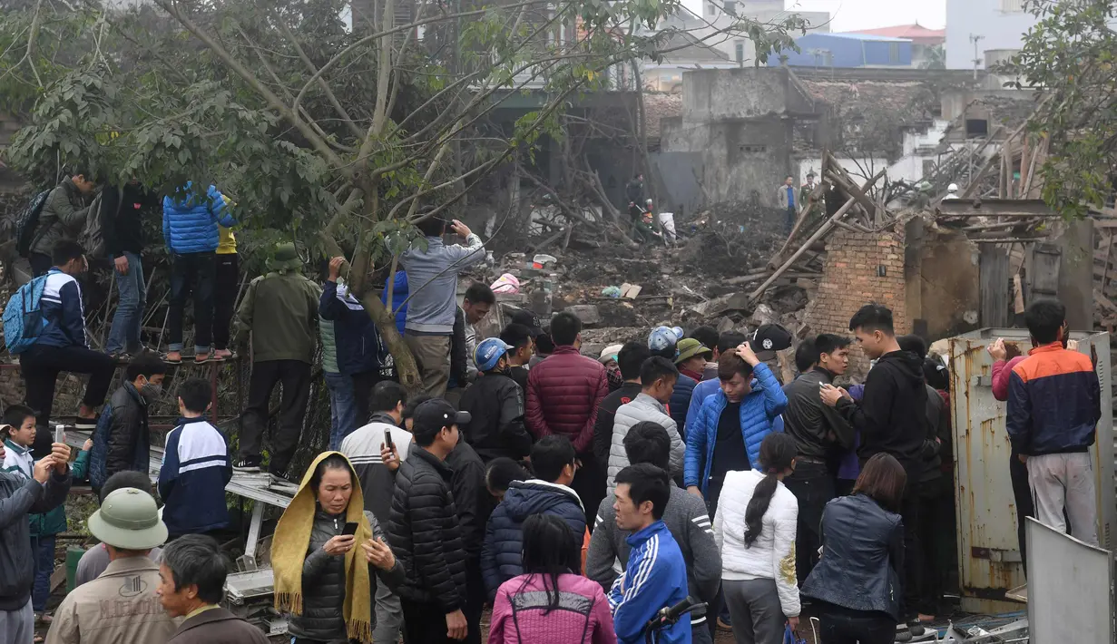 Warga melihat lokasi ledakan besar yang menghancurkan lima rumah dan bangunan di provinsi utara Bac Ninh, Vietnam (3/1). Seorang bayi dan anak perempuan berusia lima tahun tewas dalam ledakan tersebut. (AFP Photo/Hoang Dinh Nam)