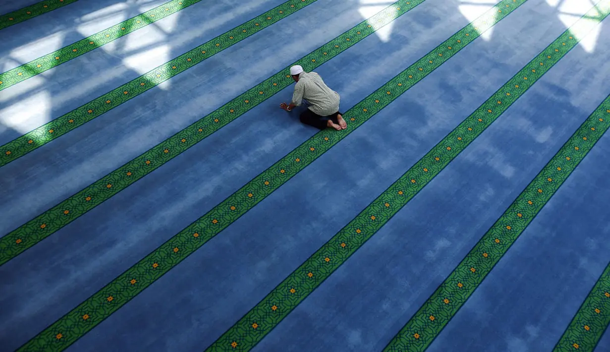 Salah satu umat muslim di Malaysia melakukan shalat disela-sela istirahat siang di hari kedua Ramadan,  (30/6/2014). (REUTERS/Samsul Said)