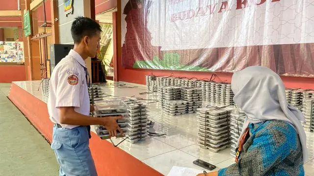 Salah satu siswa di SMA Negeri Kudus sedang mengambil kotak menu MBG. (Liputan6.com/Arief Pramono)