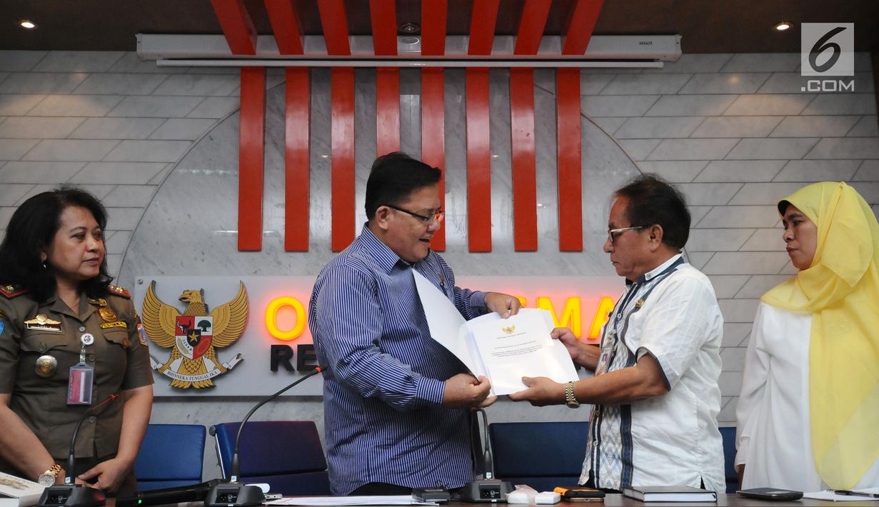 Komisioner Ombudsman RI, Adrianus Meliala (kedua kiri) menyerahkan hasil investigasi terkait Penataan PKL oleh Satpol PP DKI Jakarta kepada Kepala Bagian Biro Hukum Saut Purba di Gedung Ombudsman, Jakarta, Kamis (2/11). (Liputan6.com/Helmi Fithriansyah)