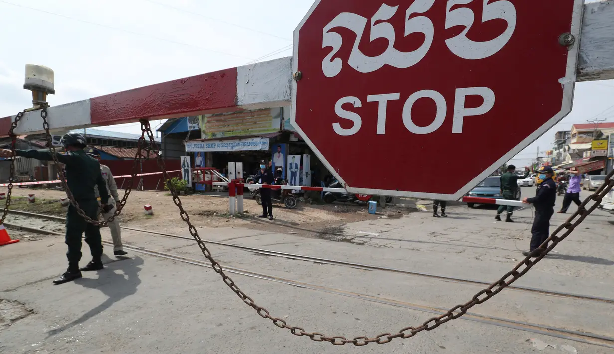 Petugas kepolisian setempat berjaga di jalan yang diblokir dekat bandara Internasional Phnom Penh di Phnom Penh, Kamis (15/4/2021). Pemimpin Kamboja memutuskan untuk lockdown atau karantina Phnom Penh selama dua minggu mulai Kamis (15/4) menyusul kenaikan tajam kasus COVID-19. (AP Photo/Heng Sinith)