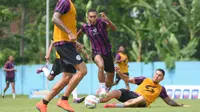 Pemain Arema FC, Ginanjar Wahyu, saat melewati hadangan rekannya dalam latihan di lapangan ARG Kabupaten Malang. (Bola.com/Iwan Setiawan)