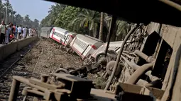 Sejumlah gerbong kereta penumpang usai tergelincir saat melintasi jalur di daerah al-Badrasheen, Giza, Mesir, (13/7). Dalam kejadian tersebut, tidak ada korban jiwa dan sekitar 55 penumpang terluka. (AFP Photo/Stringer)