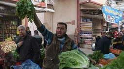 Seorang penjual produk segar Palestina memanggil pelanggan di pasar menjelang buka puasa selama bulan suci Ramadhan di kota Rafah, Jalur Gaza selatan, pada 10 April 2022. (SAID KHATIB / AFP)