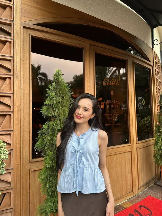 Beby Tsabina tampil manis mengenakan atasan tanpa lengan berpita berwarna biru muda yang cantik, dipadunya dengan rok panjang cokelat. [Foto: Instagram/bebytsabina]
