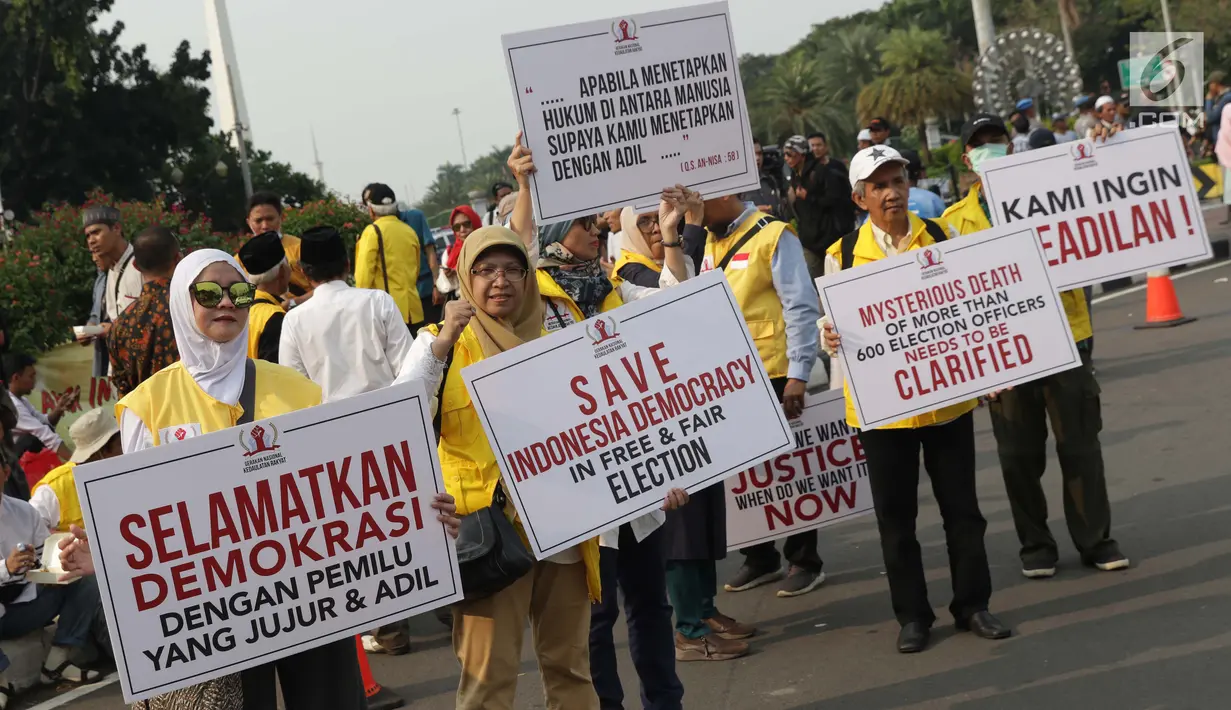 Massa berkumpul menyampaikan pendapat dan membentangkan tulisan terkait sidang perselisihan hasil pilpres 2019 di sekitar Patung Arjuna Wiwaha Jalan Medan Merdeka Barat, Jakarta, Jumat (14/6/2019). Massa meminta sidang berlangsung adil. (Liputan6.com/Helmi Fithriansyah)