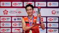 Tunggal putra Jepang, Kento Momota memegang trofinya setelah mengalahkan Anthony Sinisuka Ginting dari Indonesia pada laga final BWF World Tour Finals 2019 di Tianhe Gymnasium, Guangzhou, China, Minggu (15/12/2019).  Anthony Ginting takluk 21-17, 17-21, 14-21. (AP/Andy Wong)
