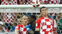 Pemain depan Kroasia Mario Mandzukic (kanan) menyundul bola dan mencetak gol bunuh diri setelah tendangan bebas pemain Prancis Antoine Griezmann pada pertandingan final Piala Dunia 2018 di Stadion Luzhniki Moskow, (15/7). (AFP PHOTO / Ganda Andersen)