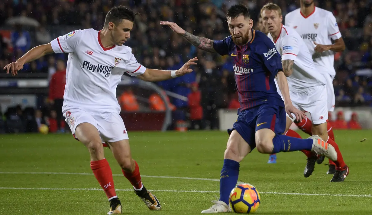 Aksi Lionel Messi (kanan) saat akan melewati pemain Sevilla, Sebastien Corchia pada lanjutan La Liga Santander di Camp Nou stadium, Barcelona, (4/11/2017). Barcelona menang 2-1. (AFP/Josep Lago)