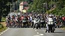 Rombongan pebalap dihentikan semenatara oleh regulator balapan karena terjadi demonstrasi perubahan iklim yang menutup rute balapan pada etape ke-10 Tour de France, antara Morzine dan Megeve, di Pegunungan Alpen Prancis, pada 12 Juli 2022. (AFP/Marco Bertorello)