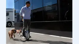 Pebalap Mercedes, Lewis Hamilton, menggunakan legway saat berjalan bersama anjingnya di paddock Sirkuit Catalunya, Barcelona, (2/32016). (AFP/Lluis Gene)