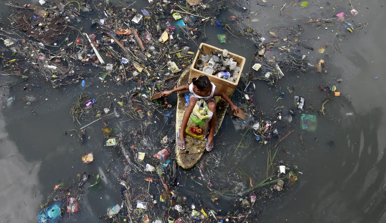 Seorang anak duduk di perahu darurat saat mengumpulkan sampah untuk bahan daur ulang di sebuah sungai yang tercemar di kota navotas, Manila, Kamis (2/7/2015). Daur ulang bertujuan untuk mengurangi tingkat pencemaran sungai. (REUTERS/Romeo Ranoco)