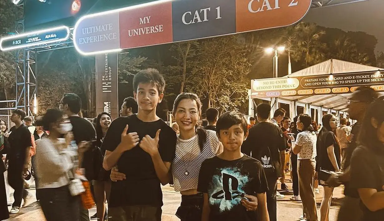Hesti Purwadinata baru saja mengajak kedua putranya menyaksikan konser Coldplay di Jakarta. Hesti tampil dengan atasan putih berjaring, sedangkan keduanya anaknya dengan kaos hitamnya. [@hestipurwadinata]