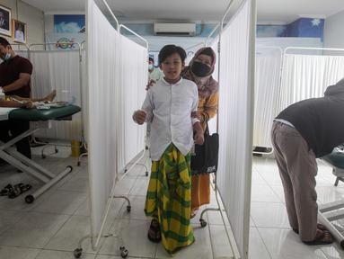 Seorang anak didampingi orang tuanya usai mengikuti sunatan massal yang diselenggarakan oleh Pemerintah Provinsi DKI Jakarta di RSUD Kebayoran Baru, Kamis (26/6/2025). (Liputan6.com/Herman Zakharia)