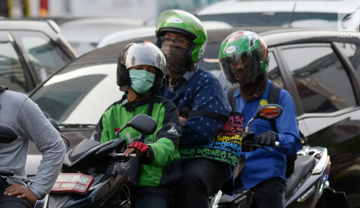 Pengendara sepeda motor mengenakan masker saat berkendara di Jakarta, Kamis (4/7/2019). Warga disarankan menggunakan masker saat berangkat kerja atau beraktivitas di luar ruangan akibat kualitas udara Jakarta yang buruk. (merdeka.com/Imam Buhori)