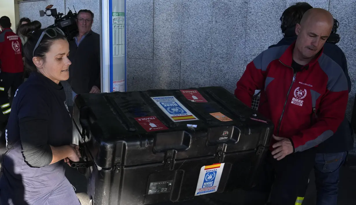 Petugas pemadam kebakaran Spanyol memuat koper ke troli bandara di bandara internasional Barajas dalam perjalanan untuk membantu misi penyelamatan di Turki sebelum menaiki penerbangan di Madrid, Spanyol, Senin (6/2/2023). Gempa kuat telah merobohkan beberapa bangunan di Turki tenggara dan Suriah dan banyak korban dikhawatirkan. (AP Photo/Paul White)
