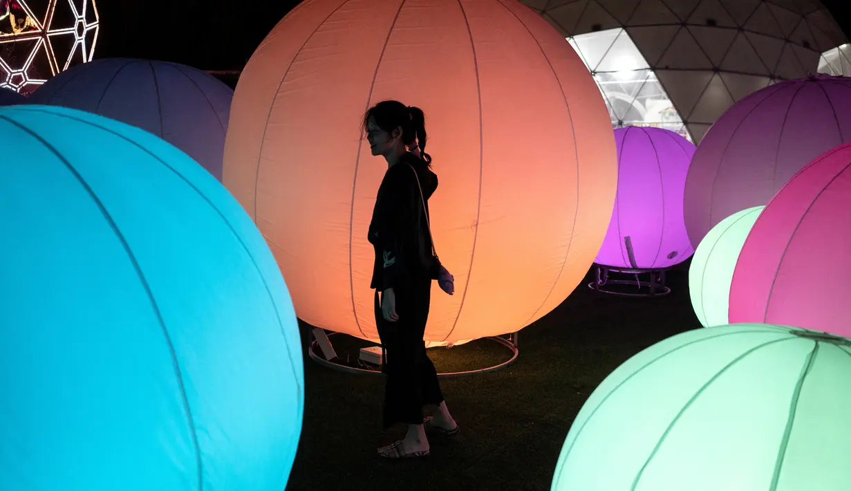 Seorang wanita melihat pameran seni cahaya yang berjudul "Halo Park" di Chaoyang Park, Beijing (7/5). Dalam pameran ini lebih dari 20 hiburan visual acousto-optik ditampilkan. (AFP/Fred Dufour)