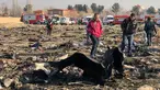 Orang-orang berjalan di antara puing-puing setelah pesawat Boeing 737 jatuh di dekat Bandara Internasional, Teheran, Iran, Rabu (8/1/2020). Seluruh penumpang pesawat maskapai Ukraina yang membawa 176 orang termasuk kru tersebut dilaporkan tewas. (AFP Photo)