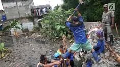 Petugas gabungan bergotong royong memperbaiki tanggul yang jebol di Kelurahan Jatipadang, Jakarta Selatan, Selasa (12/12). Perbaikan tanggul sementara itu dilakukan dengan membuat tanggul pasir lalu menahannya dengan kayu. (Liputan6.com/Immanuel Antonius)