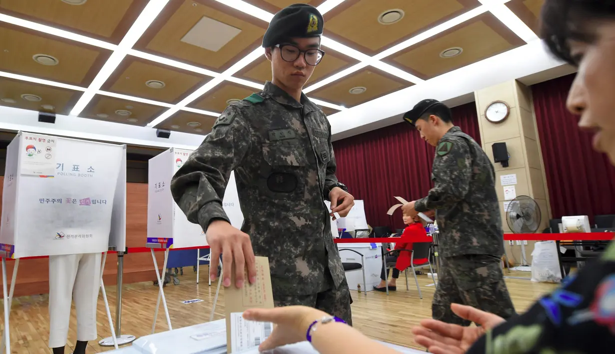 Tentara Korea Selatan (Korsel) memasukkan kertas suara di sebuah TPS di Seoul, Kamis (4/5). Selama 2 hari, masyarakat yang terdaftar sebagai pemilih dapat memberikan suara sebelum pemilihan presiden (Pilpres) pada 9 Mei mendatang. (JUNG Yeon-Je/AFP)