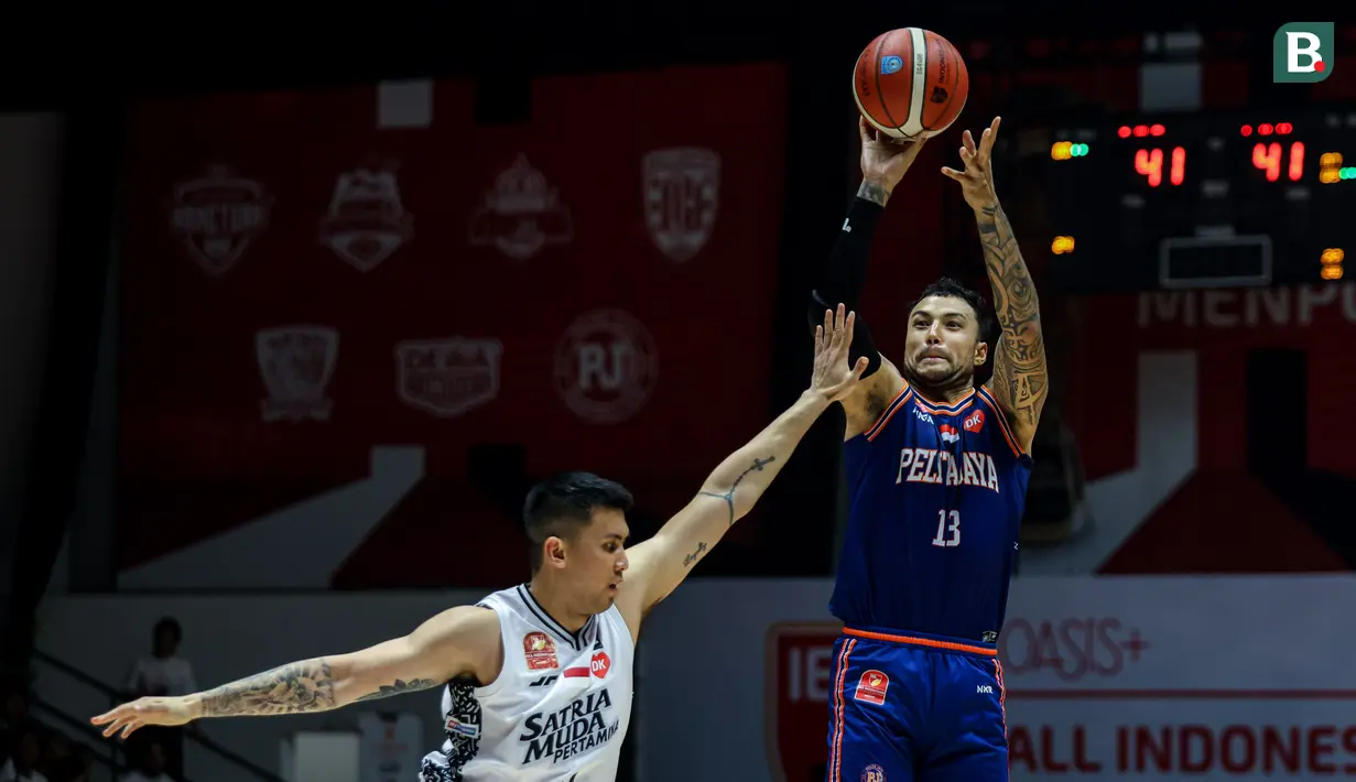 Pemain Pelita Jaya, Brandon Jawato (kanan) menembakkan bola ke arah ring dibayangi pemain Satria Muda, Juan Laurent Kokodiputra pada gim ketiga final IBL All Indonesia 2024 yang berlangsung di Hall Basket, Senayan, Jakarta, Sabtu (07/10/2024). (Bola.com/Bagaskara Lazuardi)