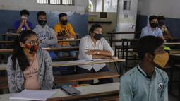 Siswa yang mengenakan masker menghadiri kelas saat sekolah dibuka kembali setelah ditutup selama berbulan-bulan karena pandemi COVID-19 di Ahmedabad, India, Senin (11/1/2021). Negara bagian Gujarat telah membuka kembali sekolah hanya untuk kelas 10 dan 12. (AP Photo/Ajit Solanki)