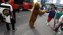 Seorang aktivis yang mengenakan kostum orangutan tampak menyapa warga di Jalan Sudirman, Jakarta, Minggu (30/11/2014).(Liputan6.com/Faizal Fanani)